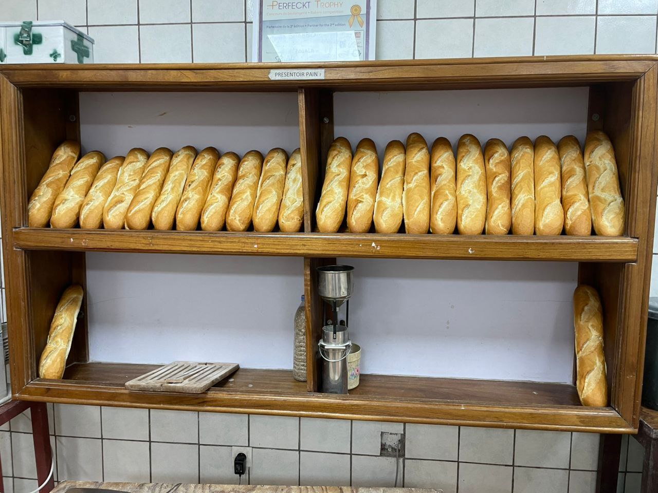 Baguettes fraîches dorées dans un présentoir de boulangerie traditionnelle